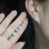 Model wearing four-prong solitaire moissanite stud earrings