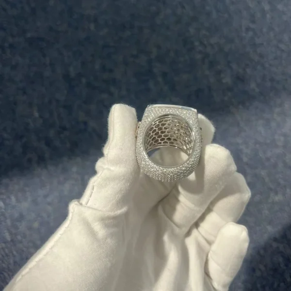 Close up of Hip Hop Champion Ring in sterling silver with moissanite, 14K white gold plated, iced out ring held in hand showing Bottom view
