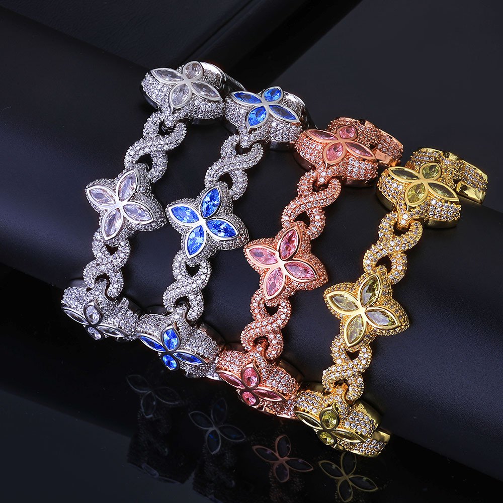 Four Colorful Lucky Clover Iced Cuban Link chains in different colors draped over a cylinder for wrist display.