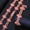 Rose gold Lucky Clover Cuban Link set (necklace & bracelet) on table, bracelet flat, necklace clasp closed.