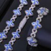 Silver Lucky Clover Cuban Link with blue CZ clovers on table, bracelet flat, necklace clasp closed.