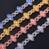 Four Colorful Lucky Clover Iced Cuban Link chains flat on black background – silver, gold, rose gold, and silver with blue CZ clovers.