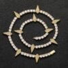 Gold panther tennis chain coiled on a black background showing iced out shine