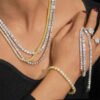 Woman wearing multiple VVS moissanite tennis chains, bracelets, and rings in 925 silver, showcasing brilliant shine