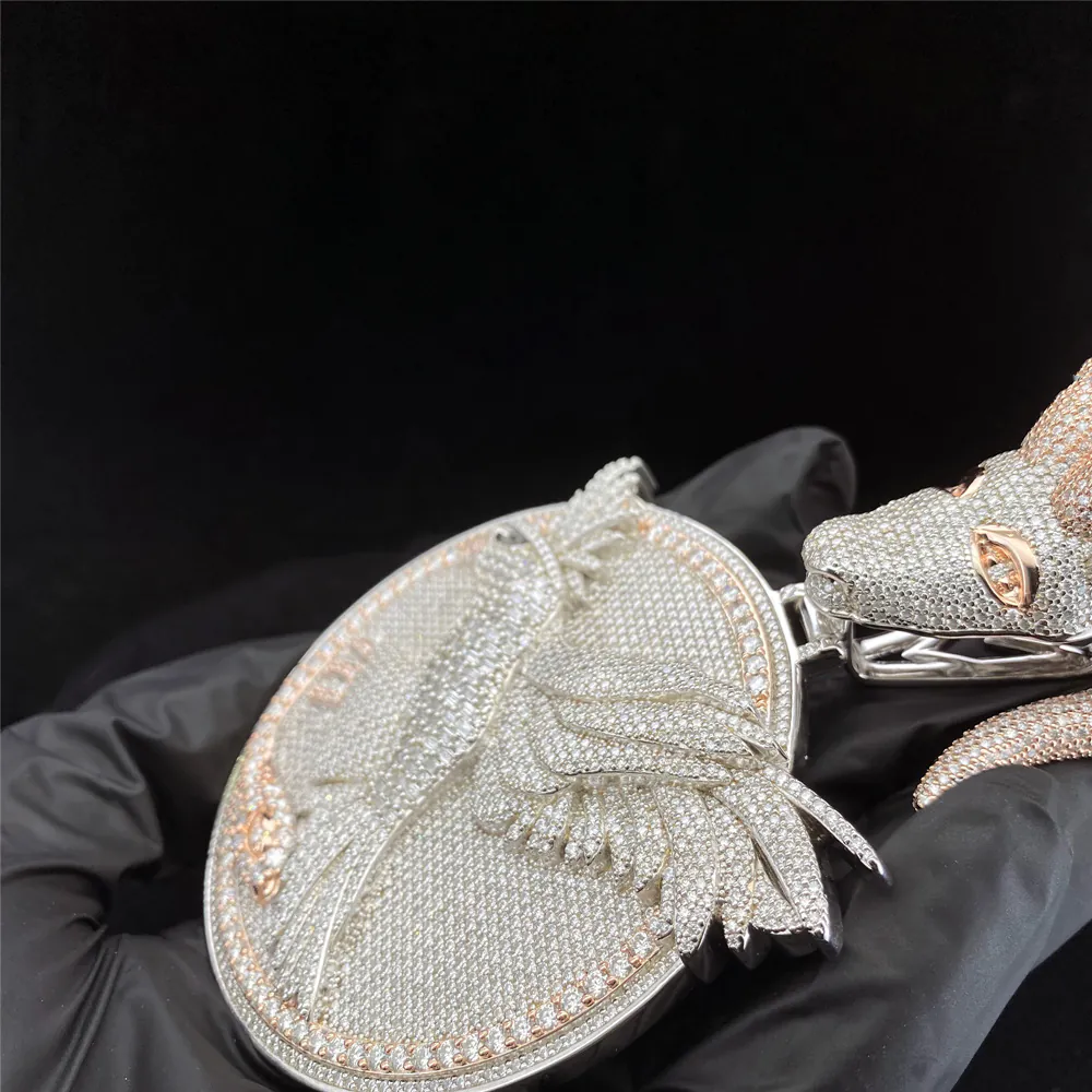 Side view of custom round disc pendant with semi-relief eagle design and goat head bail, in 925 silver with VVS moissanite, on hand