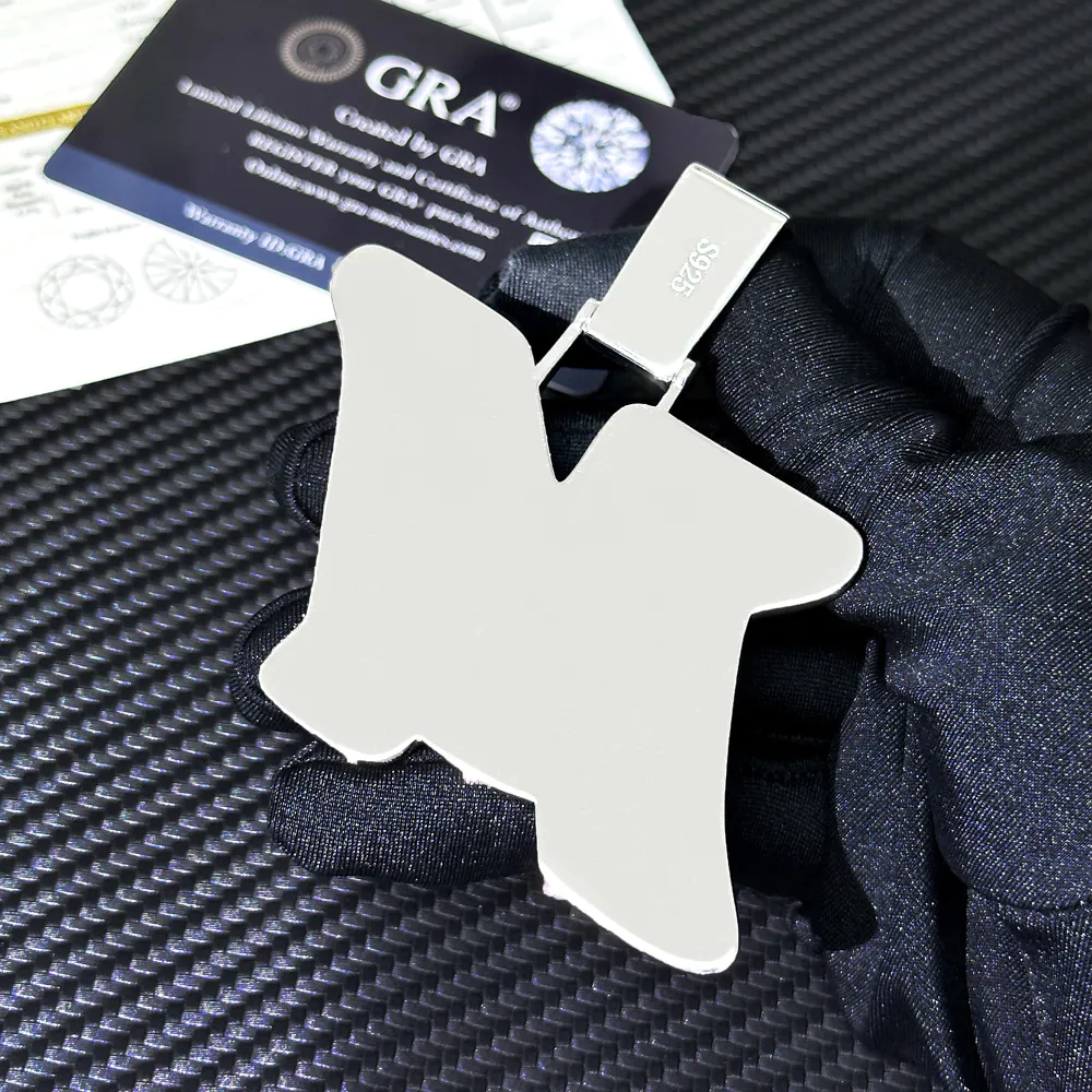 Back view of custom uppercase letter pendant in 925 silver with VVS moissanite, 14K white gold plating, held in hand.