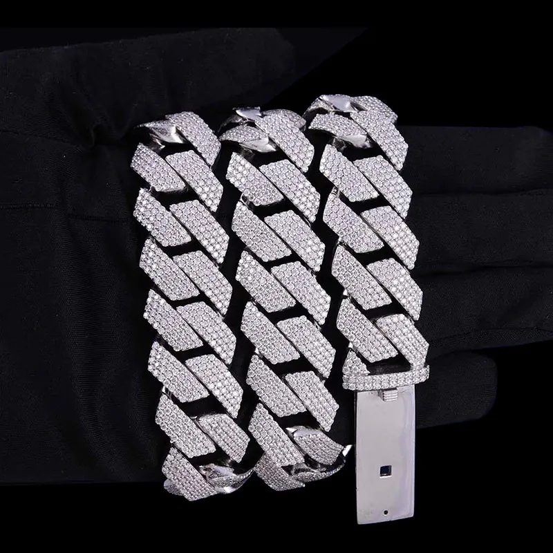 Close up of 20mm bold Cuban chain iced out in sterling silver with VVS moissanite, 14K white gold plated, box clasp detail wrapped around hand