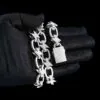 Close up of 14mm Bolt Link Chain necklace in sterling silver with VVS moissanite,   14K white gold plated,   box clasp detail wrapped around hand