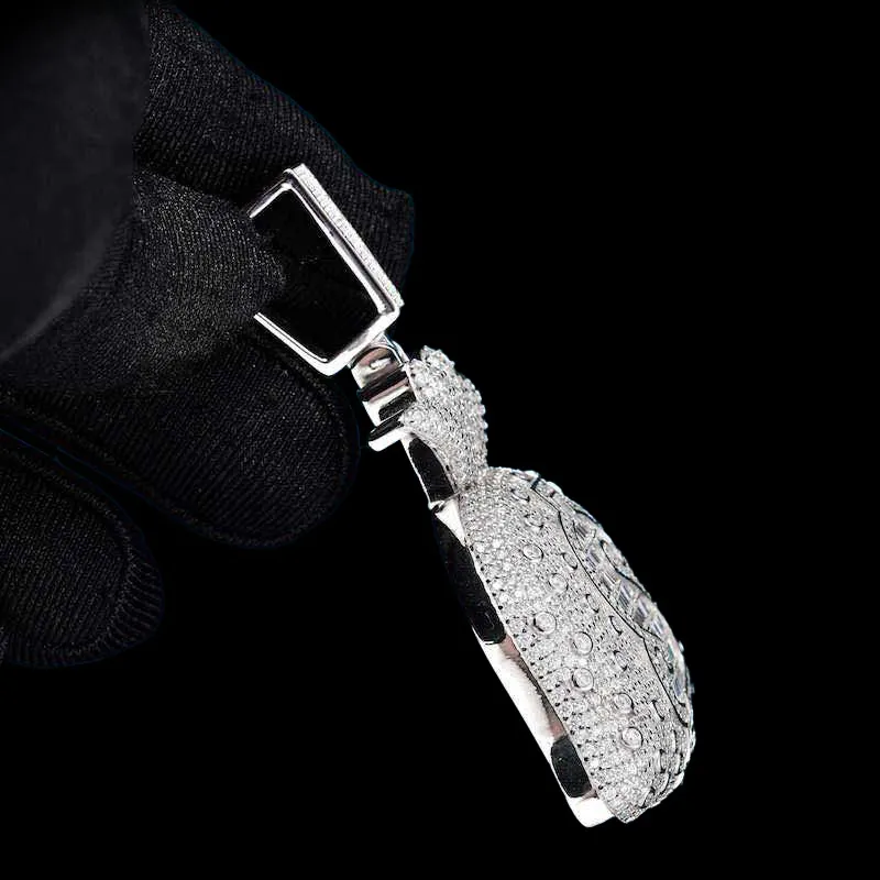 Side view of Moneybag Pendant in brass with CZ stones, 14K white gold plated, iced out pendant held in hand
