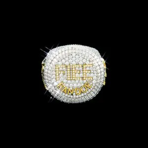 FIEE BANDOE Ring in sterling silver with moissanite, white gold plated, iced out circular top with FIEE letters in gold set with round white stones and BANDOE letters below