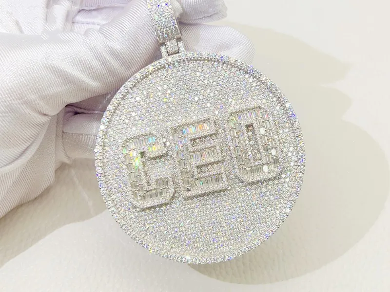 Custom pendant in 925 silver with Moissanite and 16K white gold plating, featuring 'CEO' letters on a round design.