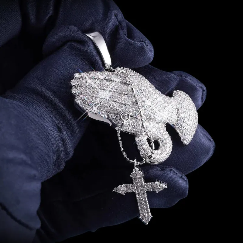 Close up of VVS Praying Hands Pendant in brass with CZ stones, 14K white gold plated, held in hand to show intricate iced out details