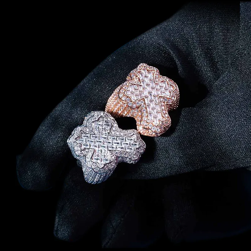 Two Fleur Cross Rings in sterling silver with moissanite, 14K white and rose gold plated, iced out rings held in hand