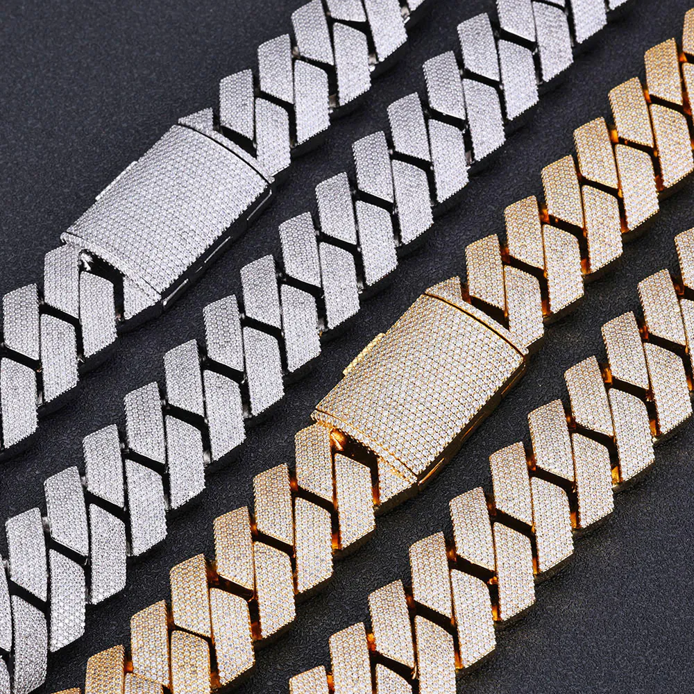 Two silver and two gold 26mm iced Cuban link chains laid flat on a black background, showcasing bold 4-row CZ stones.