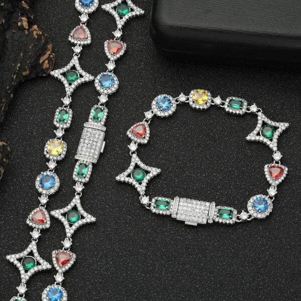 Silver colored tennis chain and bracelet set laid flat on a table with clasp closed