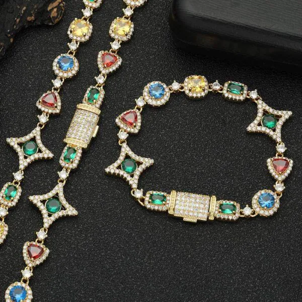 Gold colored tennis chain and bracelet set laid flat on a table with clasp closed