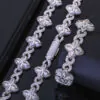 Silver Lucky Clover Cuban Link set (necklace & bracelet) on table, bracelet flat, necklace clasp closed.