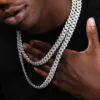 Two silver 14mm Cuban chains of different lengths displayed on a Black model’s neck