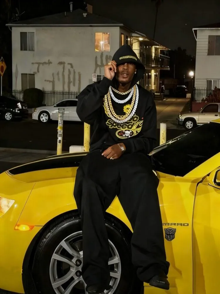 Street fashion model layering CZ Cuban Link chains in an urban outdoor scene, representing modern hip-hop jewelry style.