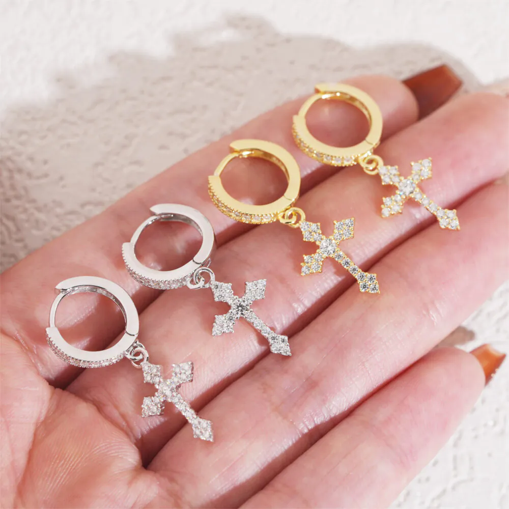 Handheld view of white gold and yellow gold moissanite cross hoop earrings