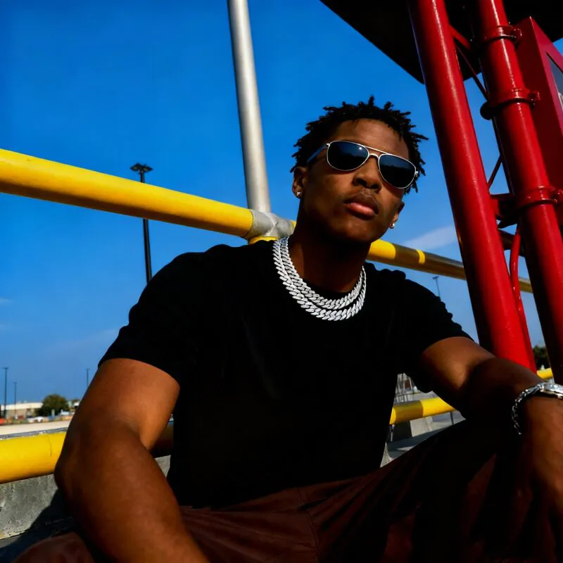Young male model wearing a CZ Miami Cuban Link chain in a streetwear outfit, showcasing bold hip-hop jewelry style.